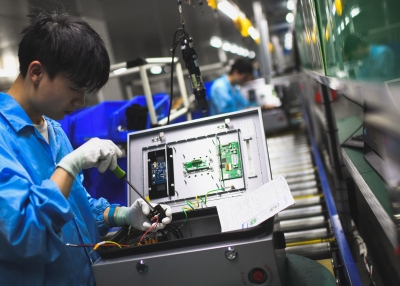 Employees working at a factory that produces electric cars charging station for export in Wuhan, in central China's Hubei province