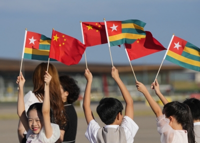 Children hold the national flags of China and Togo as they prepare for the arrival of Togo's President Faure Gnassingbe