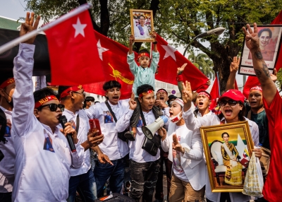 Myanmar protesters cheer while holding photos of democracy leader, Aung San Suu Kyi, during a gathering at the United Nations on February 01, 2024 in Bangkok, Thailand.